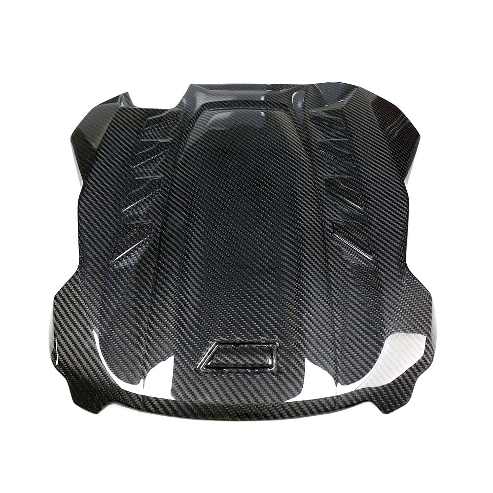 CT Carbon F95 X5M / F96 X6M dry carbon fiber engine cover accessory showing sleek, textured carbon fiber surface with branding details.