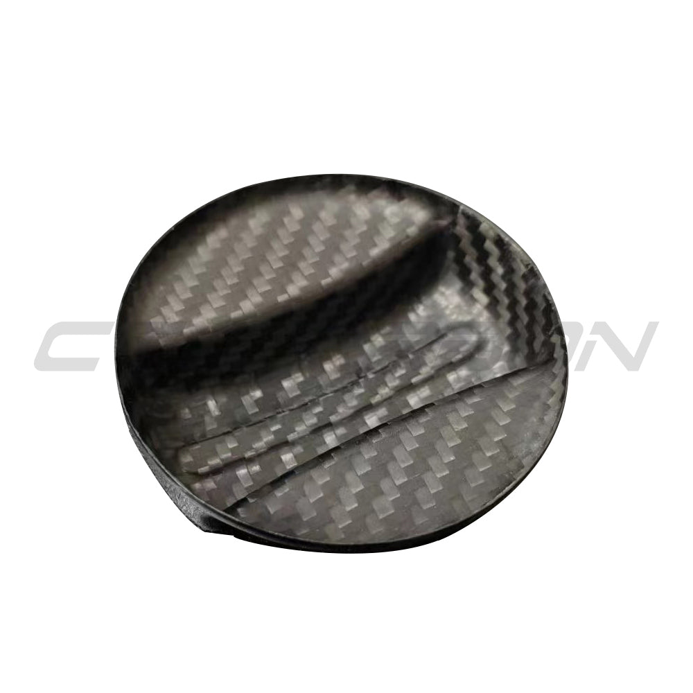 BMW 2010+ carbon fiber fuel cap cover by CT Carbon, close-up view showing sleek black finish and textured carbon fiber pattern.
