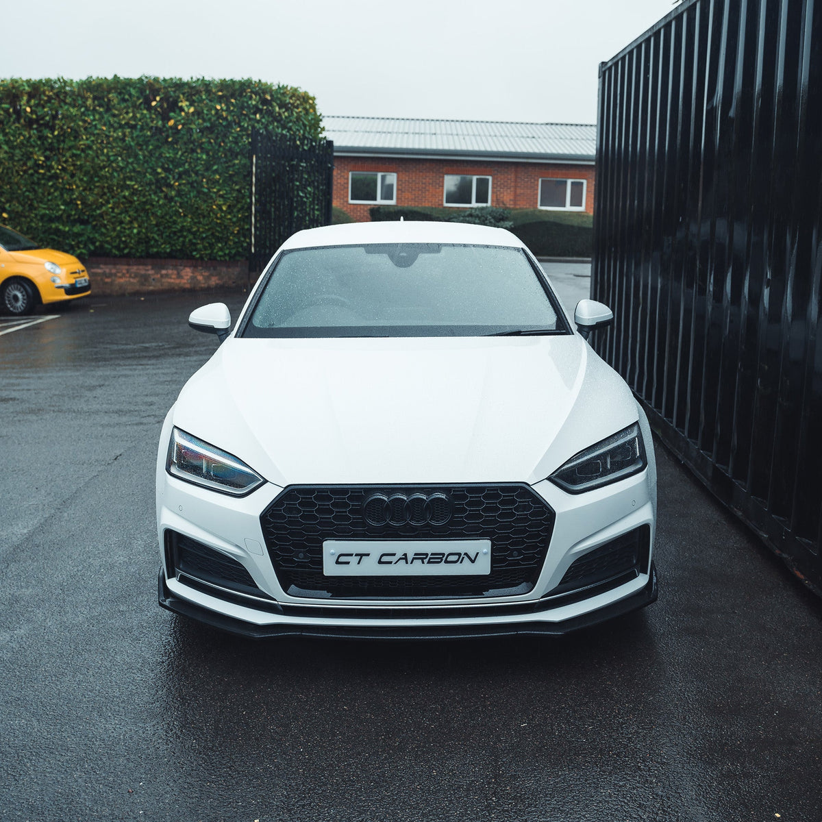 Gloss black carbon fiber splitter for Audi A5/S5 B9 2016-2019 by CT Carbon, shown on the front of the vehicle.