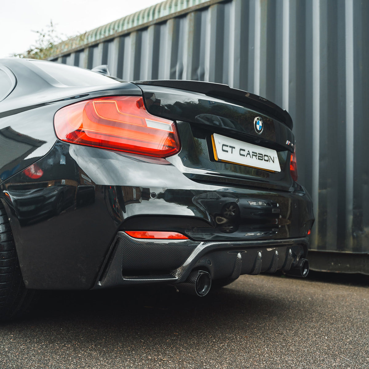 BMW 2 Series F22/F23 carbon fiber diffuser by CT Carbon, showing sleek aerodynamic design and textured carbon fiber finish.