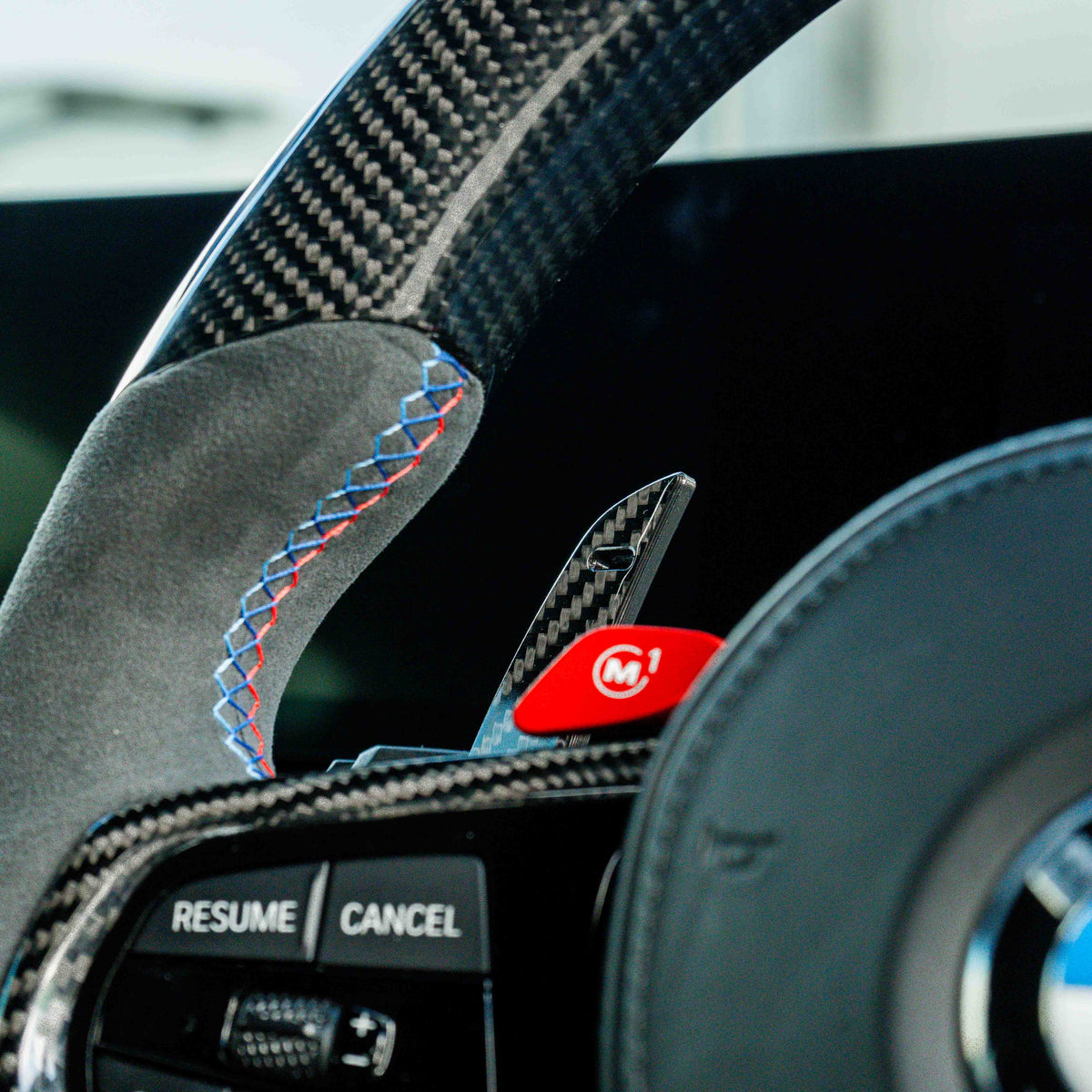 BMW carbon fiber magnetic shifter paddles by CT Carbon, lightweight accessories for sporty driving, shown on a car steering wheel.