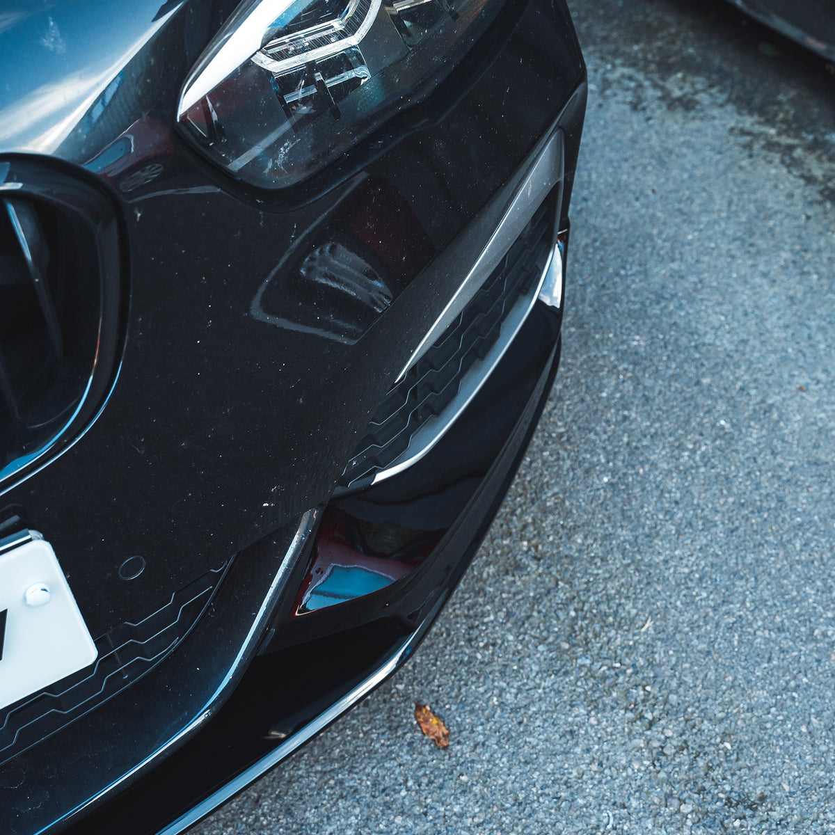 BMW F20 F21 1 Series LCI gloss black splitter by CT Carbon, close-up of the sleek, aerodynamic front splitter on the car.