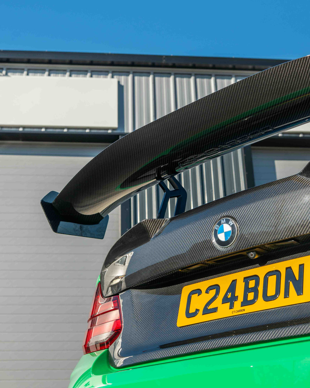 BMW F87 M2 and F22 2 Series carbon fibre swan neck wing spoiler by CT Carbon, showcasing sleek V8 design and aerodynamic details.