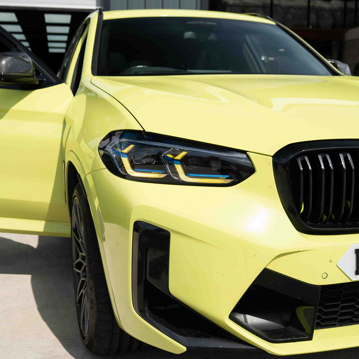 BMW F97 X3M LCI yellow adaptive DRL module set by CT Carbon, showing the bright yellow daytime running lights on the vehicle.