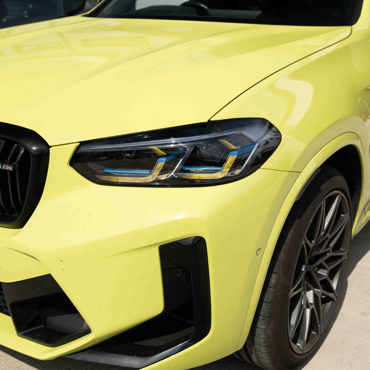 BMW F97 X3M LCI yellow adaptive DRL module set by CT Carbon, showing the bright yellow daytime running lights installed on the vehicle.