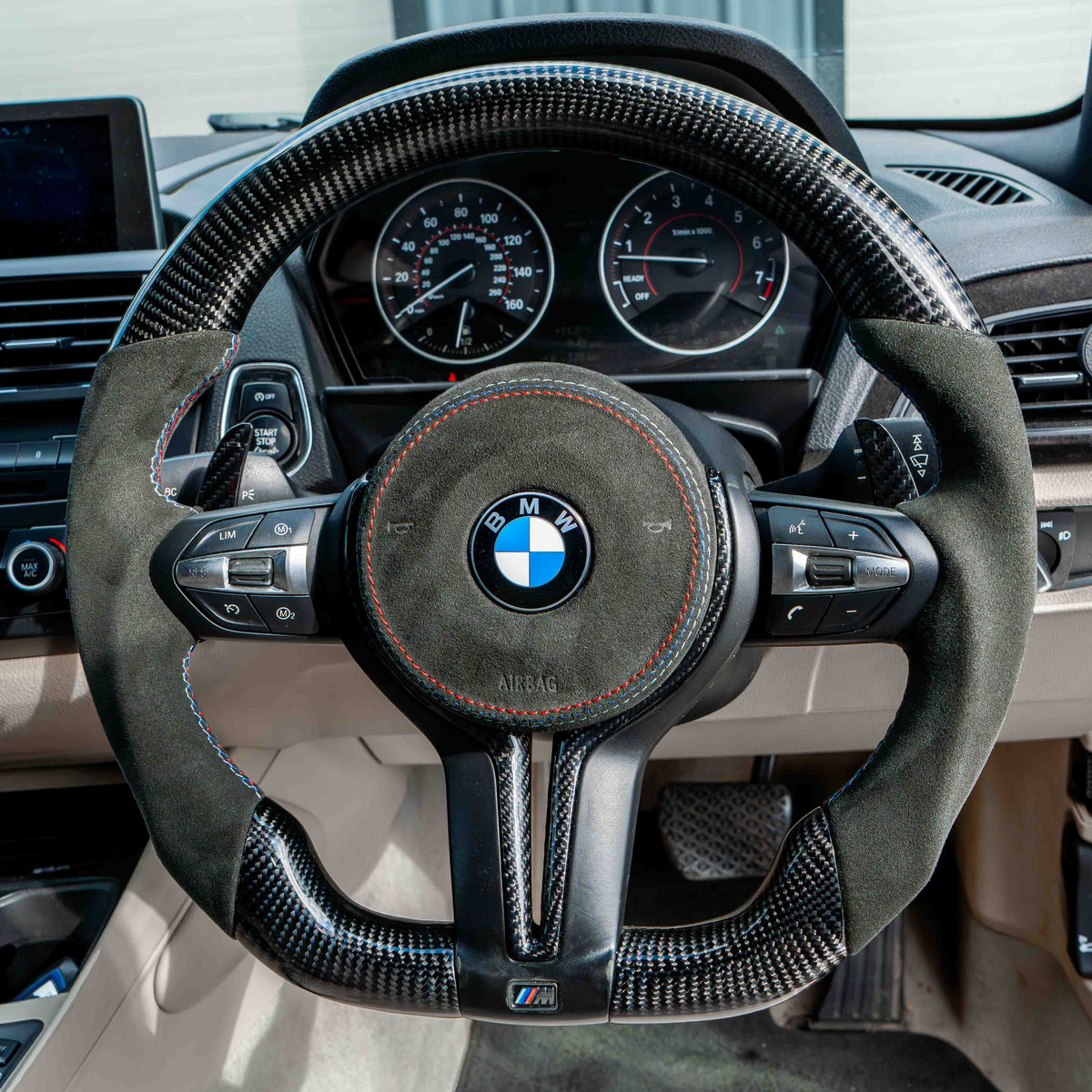 BMW Fxx carbon fiber magnetic shifter paddles, CT Carbon accessories, close-up view showing sleek black finish and paddle design.