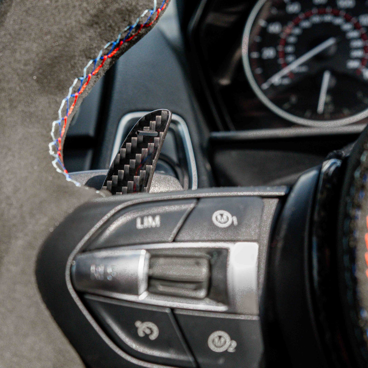 BMW Fxx carbon fibre magnetic shifter paddles from CT Carbon, close-up view showing sleek black textured design.