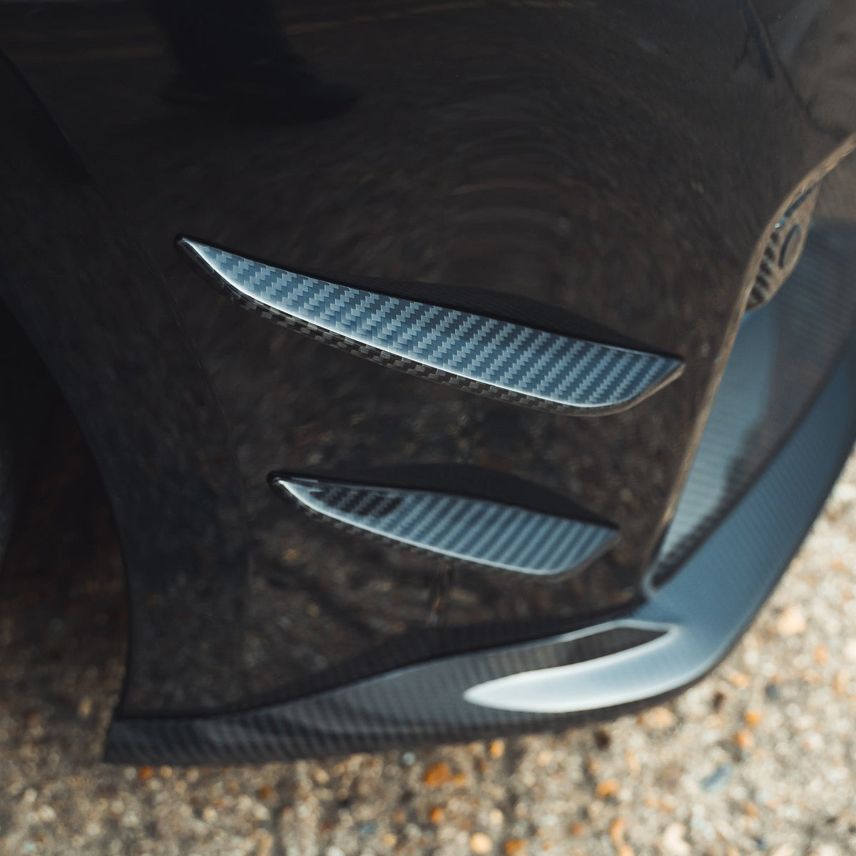BMW G87 M2 carbon fiber front bumper canards by CT Carbon, lightweight aerodynamic car accessories, mounted on the front bumper.