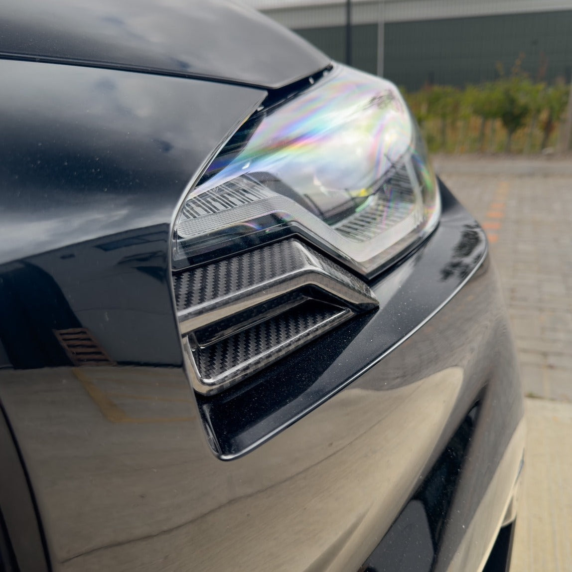 BMW G87 M2 Carbon Fibre Front Head Light Add-On accessory by CT Design, featuring sleek carbon fibre detail on vehicle headlight area