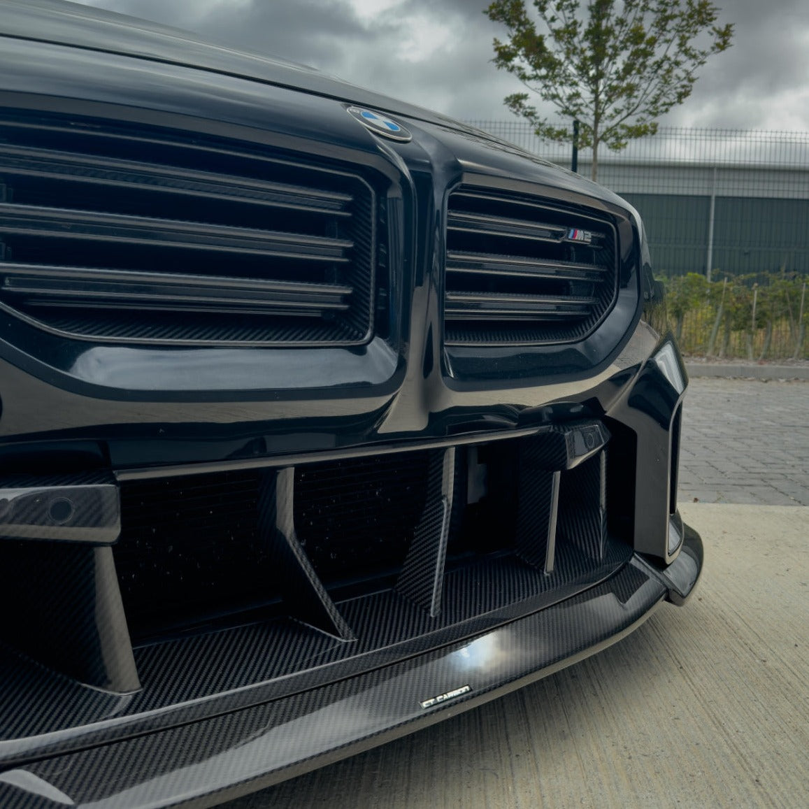 BMW G87 M2 carbon fiber lower grille by CT Design, showcasing the sleek, textured carbon fiber finish on the car accessory.