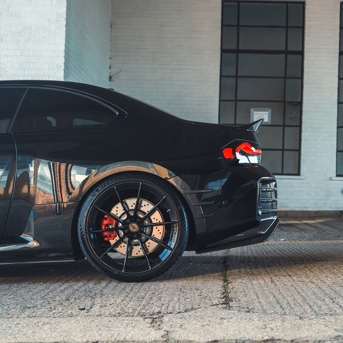 BMW G87 M2 carbon fibre rear side fender trim accessory by CT Carbon, showcasing sleek, lightweight carbon fibre design on the vehicle.