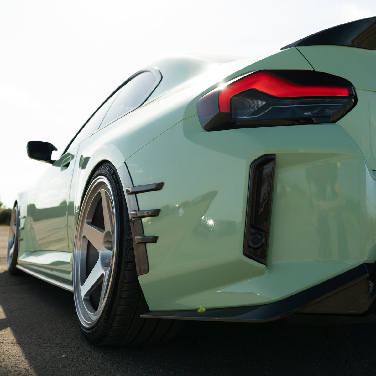 BMW G87 M2 carbon fiber rear side fender trim accessory by CT Carbon, showcasing sleek, lightweight carbon fiber design.