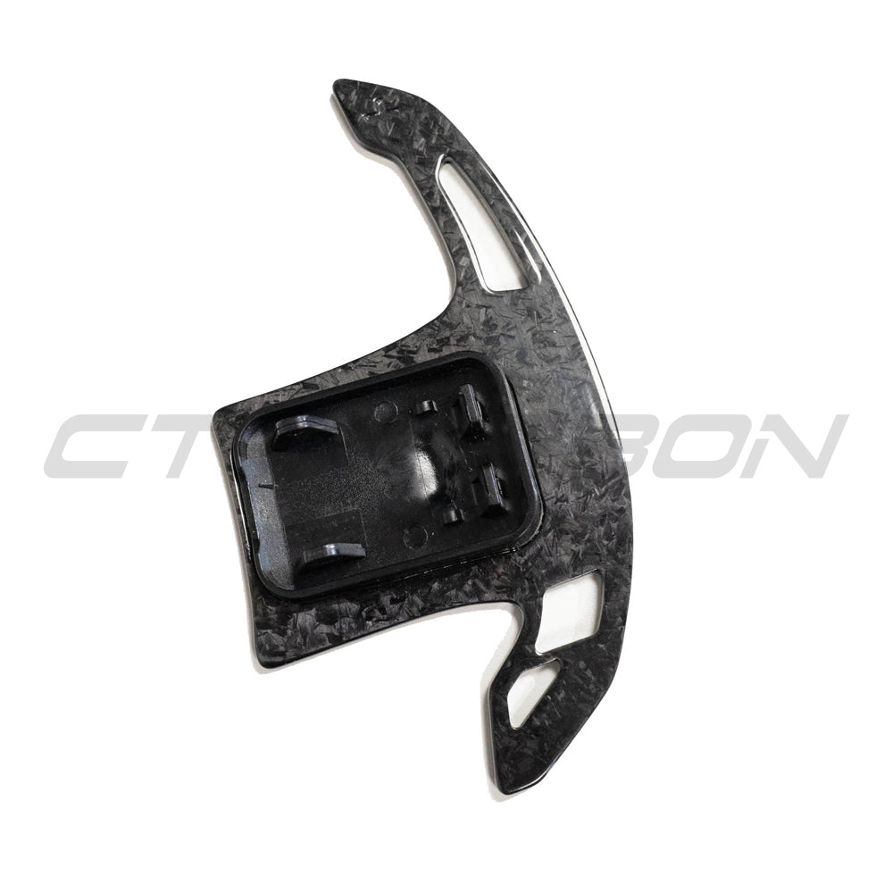 BMW Gxx forged carbon fiber shifter paddles by CT Carbon, close-up view showing sleek black carbon fiber surface and ergonomic design.