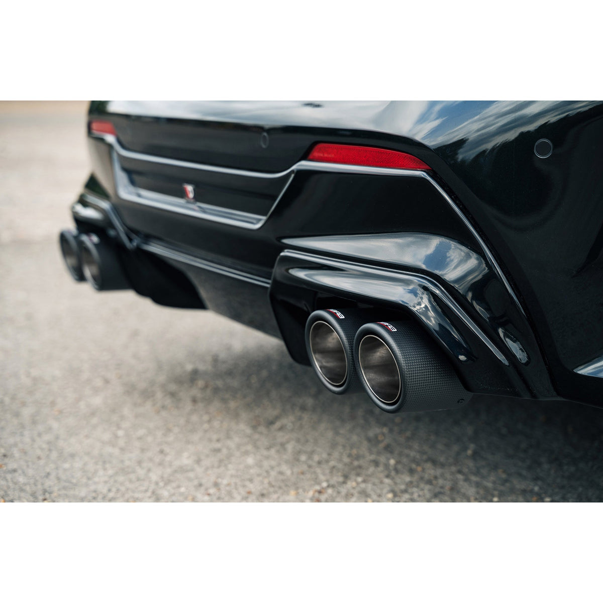 Cobra Sport BMW M135i F40 turbo back exhaust with quad exit and M3 style race box delete, installed on a black BMW.