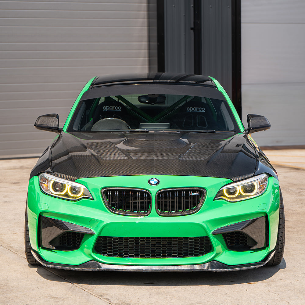 BMW M2 F87 N55 carbon fiber front bumper corners by CT Carbon, close-up of sleek, aerodynamic accessory for sport coupe.