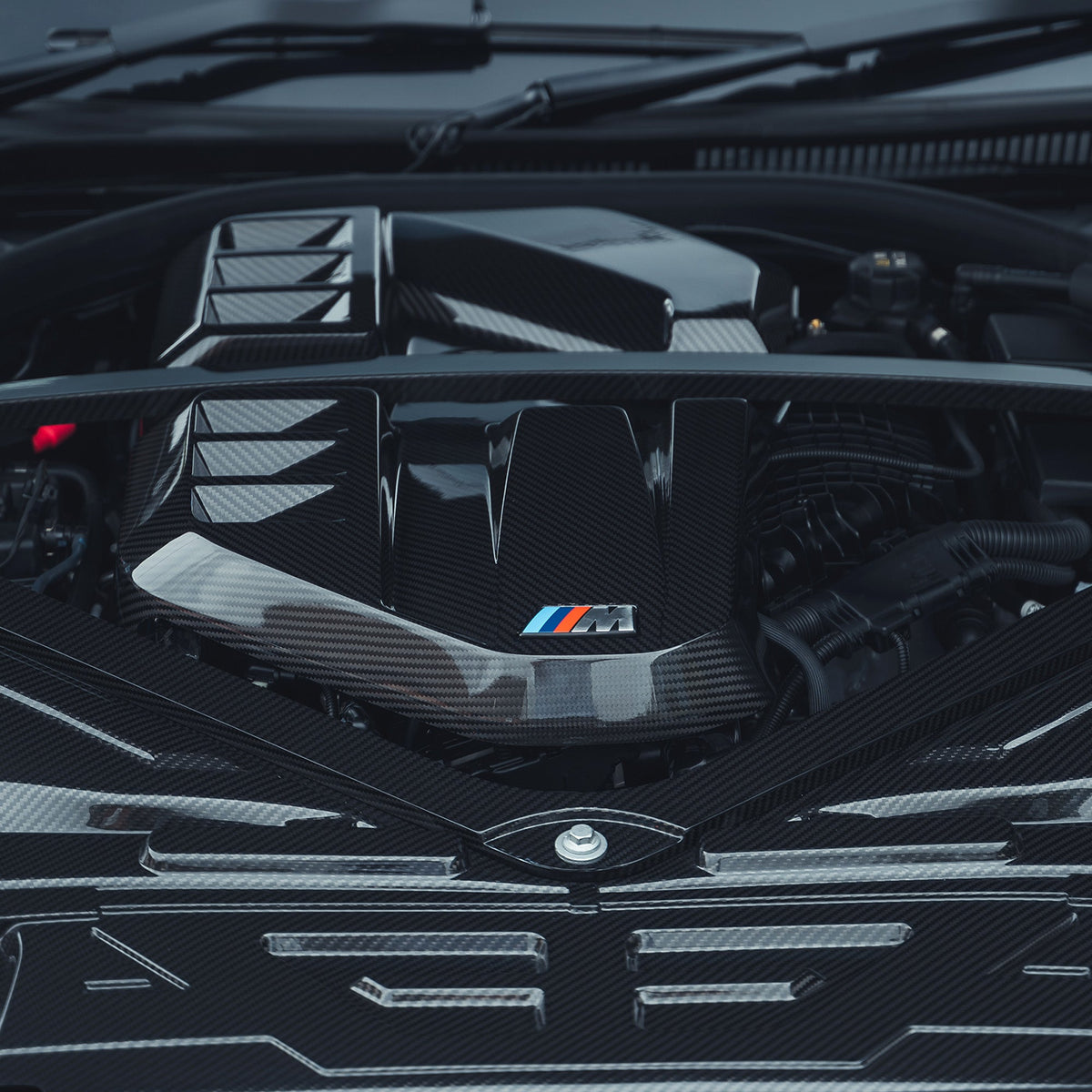 BMW M2, M3, M4 G87/G80/G81/G82/G83 carbon fiber engine dress-up kit by CT Carbon, showing sleek black carbon fiber components.