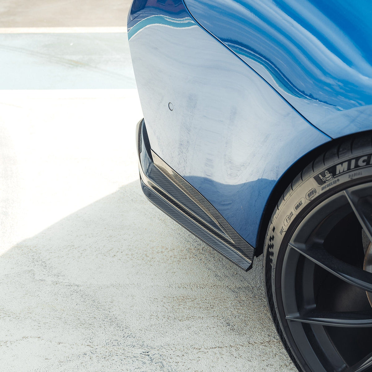 BMW M3 G80 G81 carbon fibre diffuser by CT Carbon, showcasing its sleek design and textured carbon fiber surface.