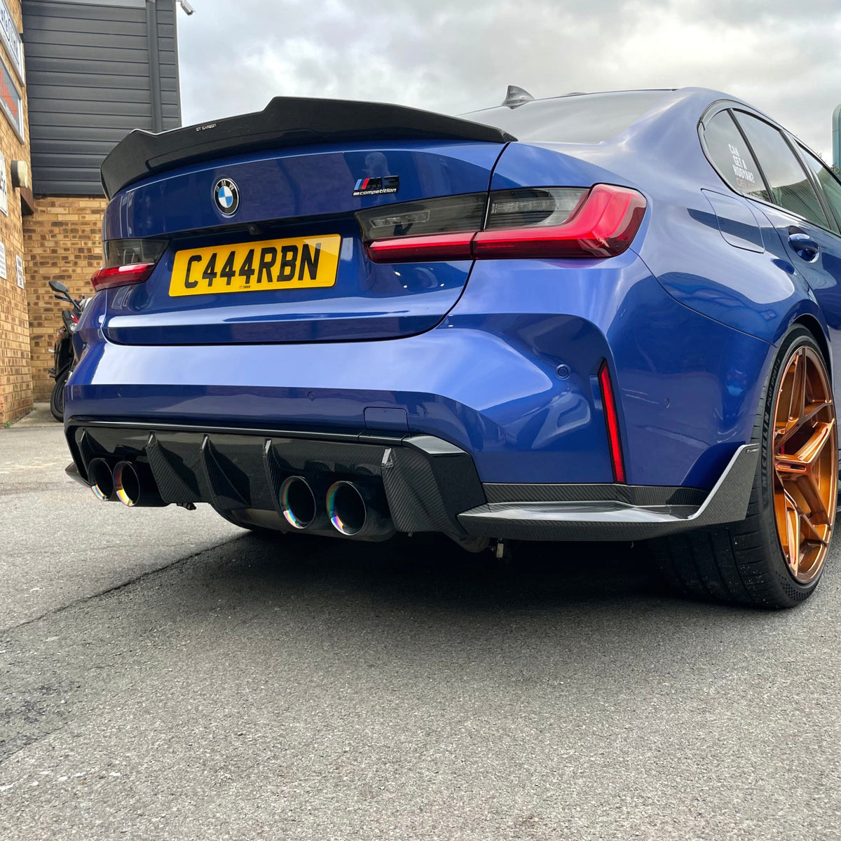 BMW M3 G80, G20 carbon fibre spoiler by CT Carbon, V2 style, shown on the car's rear for enhanced aerodynamics and sporty look.