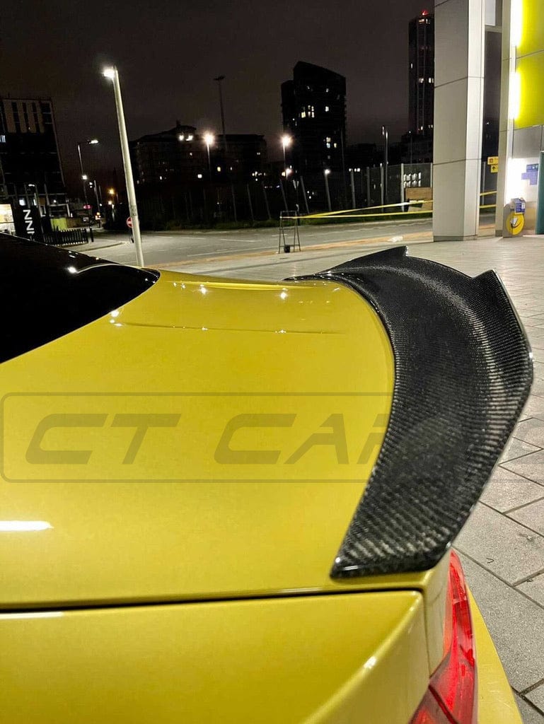 BMW M4 F82 carbon fiber spoiler with ducktail PS style, designed for aerodynamic performance and sleek sportscar appearance by CT Carbon.