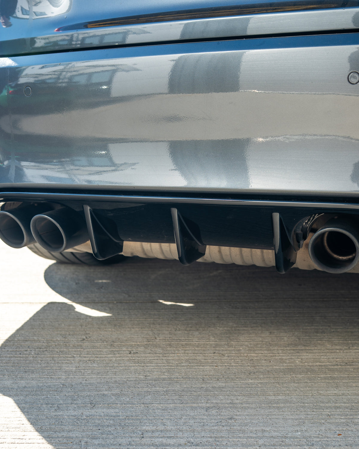 BMW M3 M4 F80 F82 F83 GLOSS BLACK V STYLE Diffuser by CT Carbon installed on coupe, showcasing sleek, aerodynamic rear design.