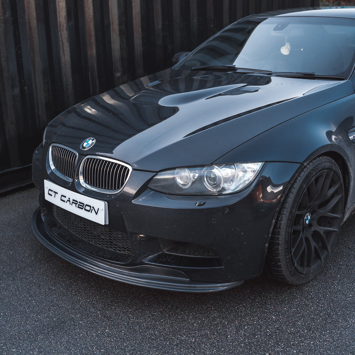 Carbon fiber splitter for BMW M3 E92/E90 2007-2013 by CT Carbon, showcasing the sleek, aerodynamic design of the V1 splitte