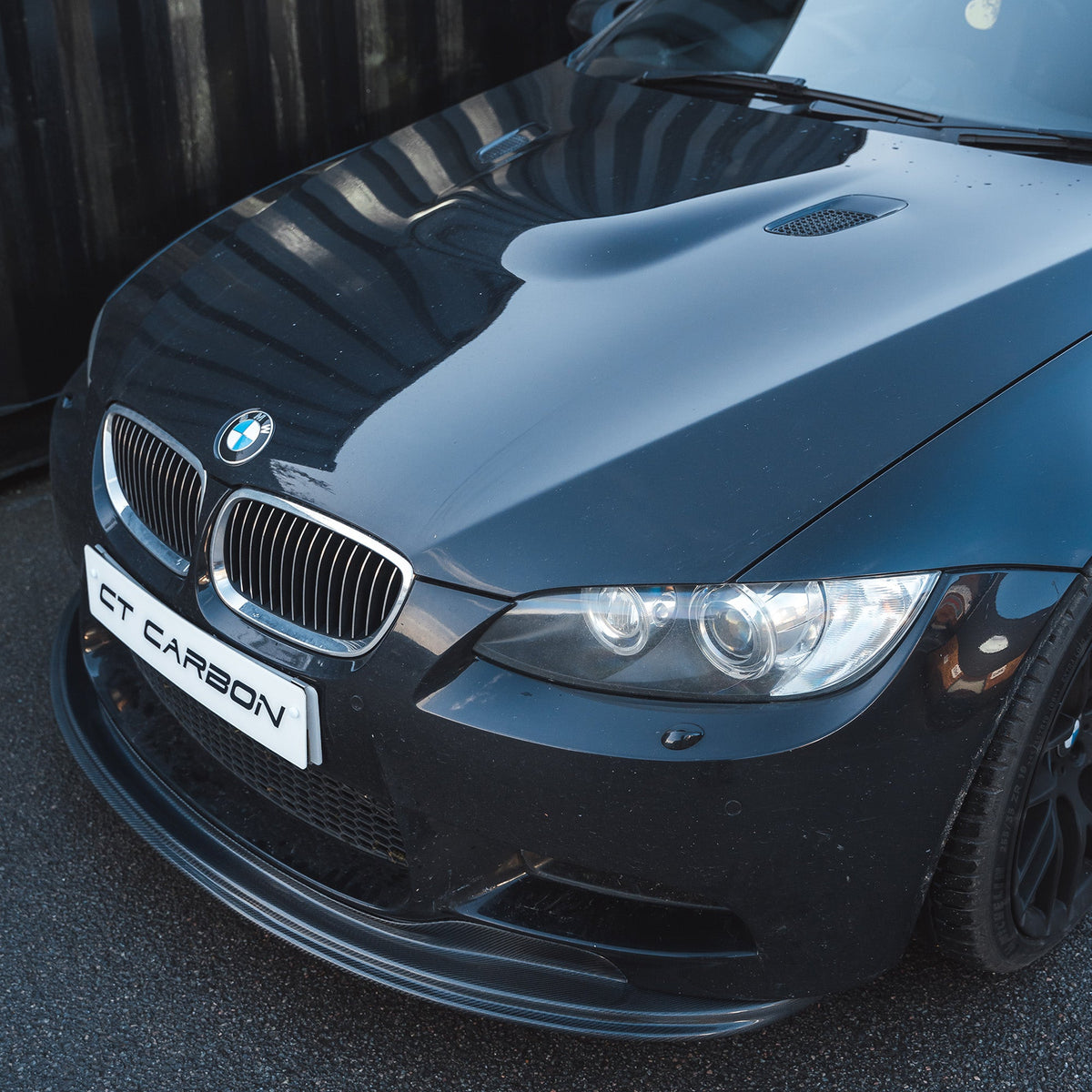 BMW M3 E92/E90 carbon fibre splitter V1 by CT Carbon, shown on the front of the car with a sleek, aerodynamic design.