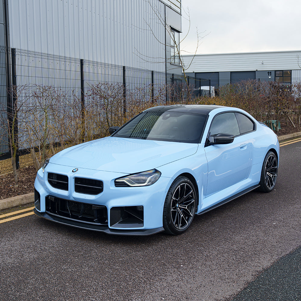 Carbon fiber splitter for BMW G87 M2 2023+ by CT Carbon, showcasing aerodynamic design and textured carbon fiber surface.