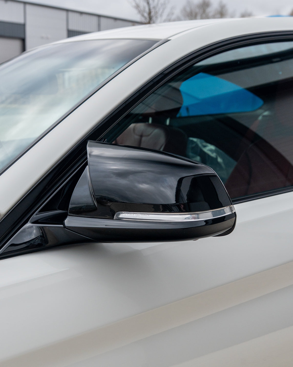 BMW Fxx 1-4 Series CT Carbon gloss black side mirrors, close-up view showing sleek, aerodynamic design and reflective surfaces.