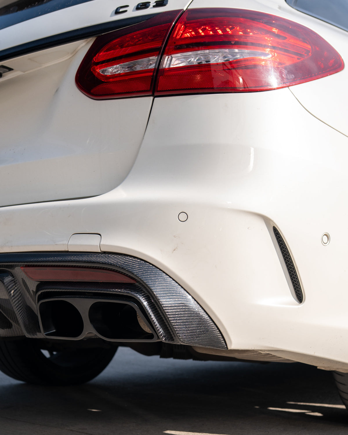 Mercedes W205 C63 C63S saloon carbon fibre diffuser with exhaust tips by CT Carbon, showing sleek aerodynamic design.