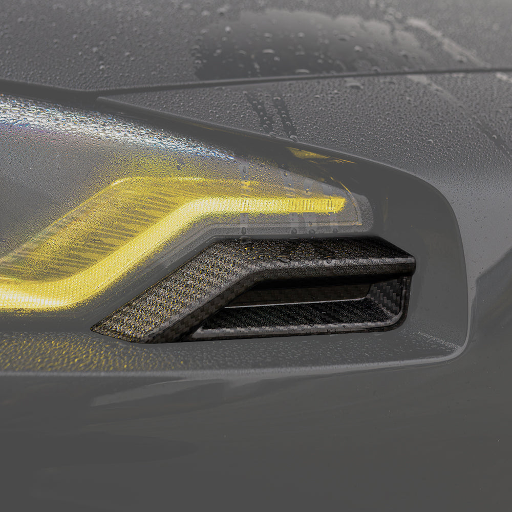 BMW G87 M2 carbon fibre front headlight add-on accessory by CT Carbon, featuring sleek carbon fiber design and high-quality finish.