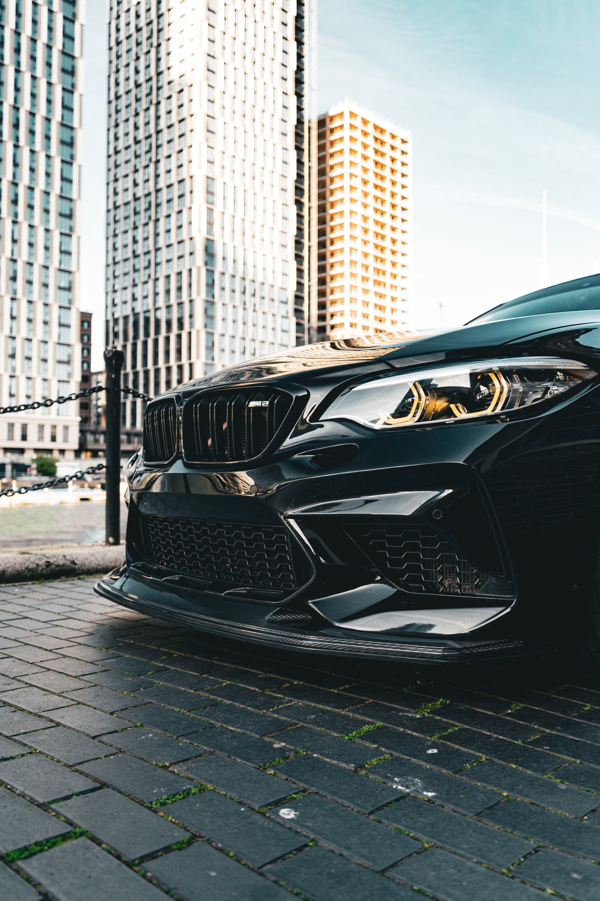 Carbon GTS front splitter for BMW M2 Competition by 72Design, showcasing sleek aerodynamic design on a black car.