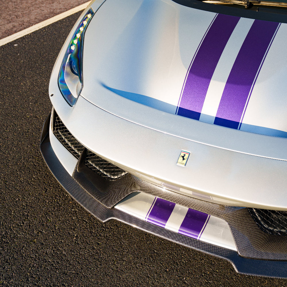Ferrari 488 Pista carbon fibre splitter by CT Carbon, showing the sleek aerodynamic design and detailed carbon fibre texture.