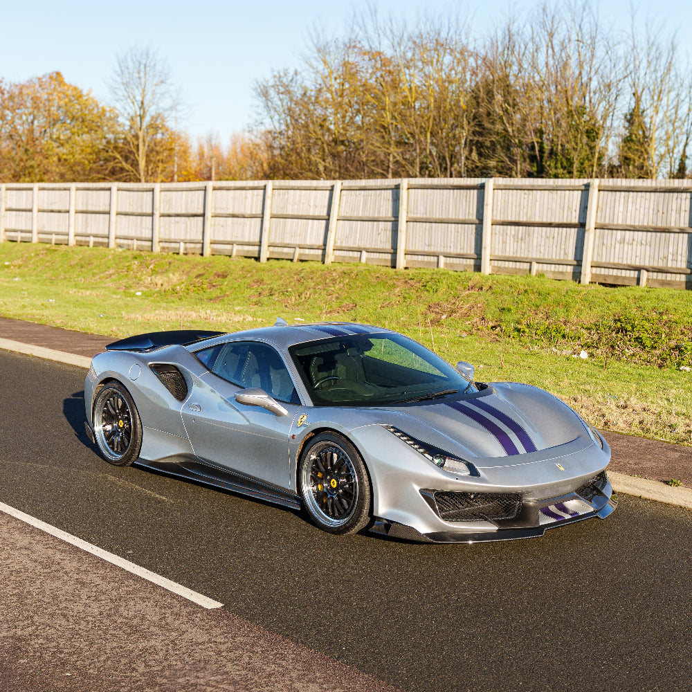 Ferrari 488 Pista carbon fibre splitter by CT Carbon, close-up view showing sleek aerodynamic design and textured carbon material.