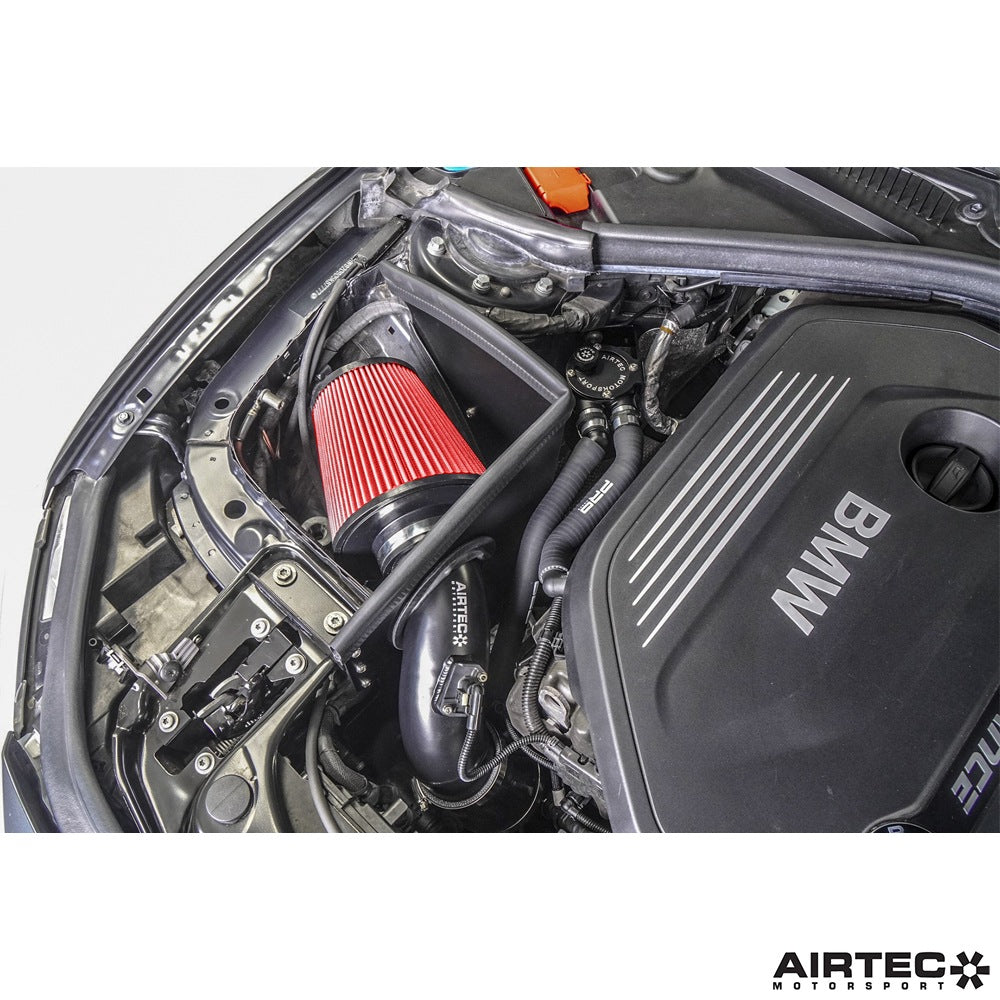 Airtec Motorsport induction kit installed in a BMW M140i/M240i engine bay, showcasing air intake components and filter.