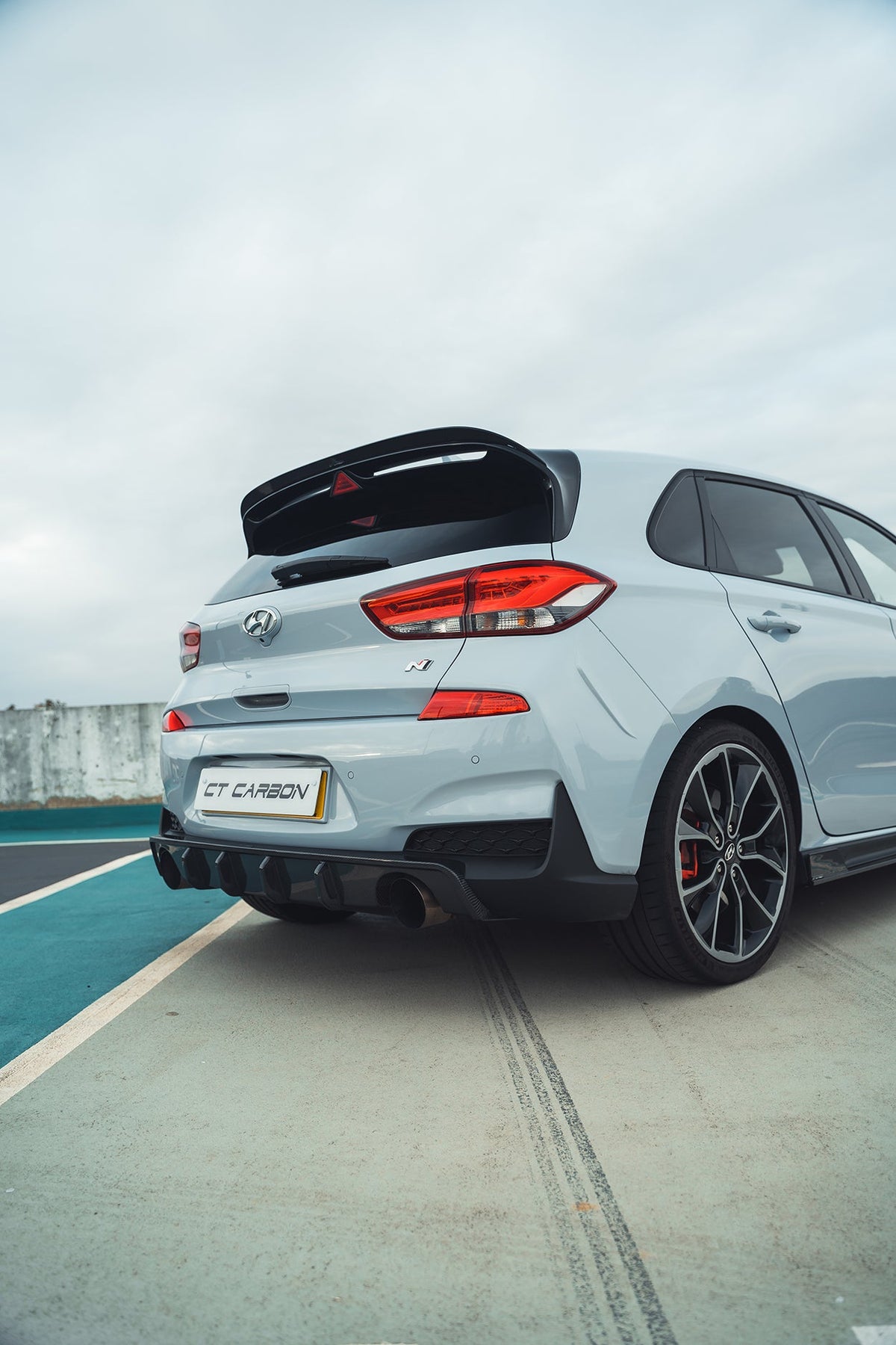 Hyundai i30N carbon fibre diffuser splitter by CT Carbon, pre-facelift model, showcasing sleek carbon fiber finish and aerodynamic design.