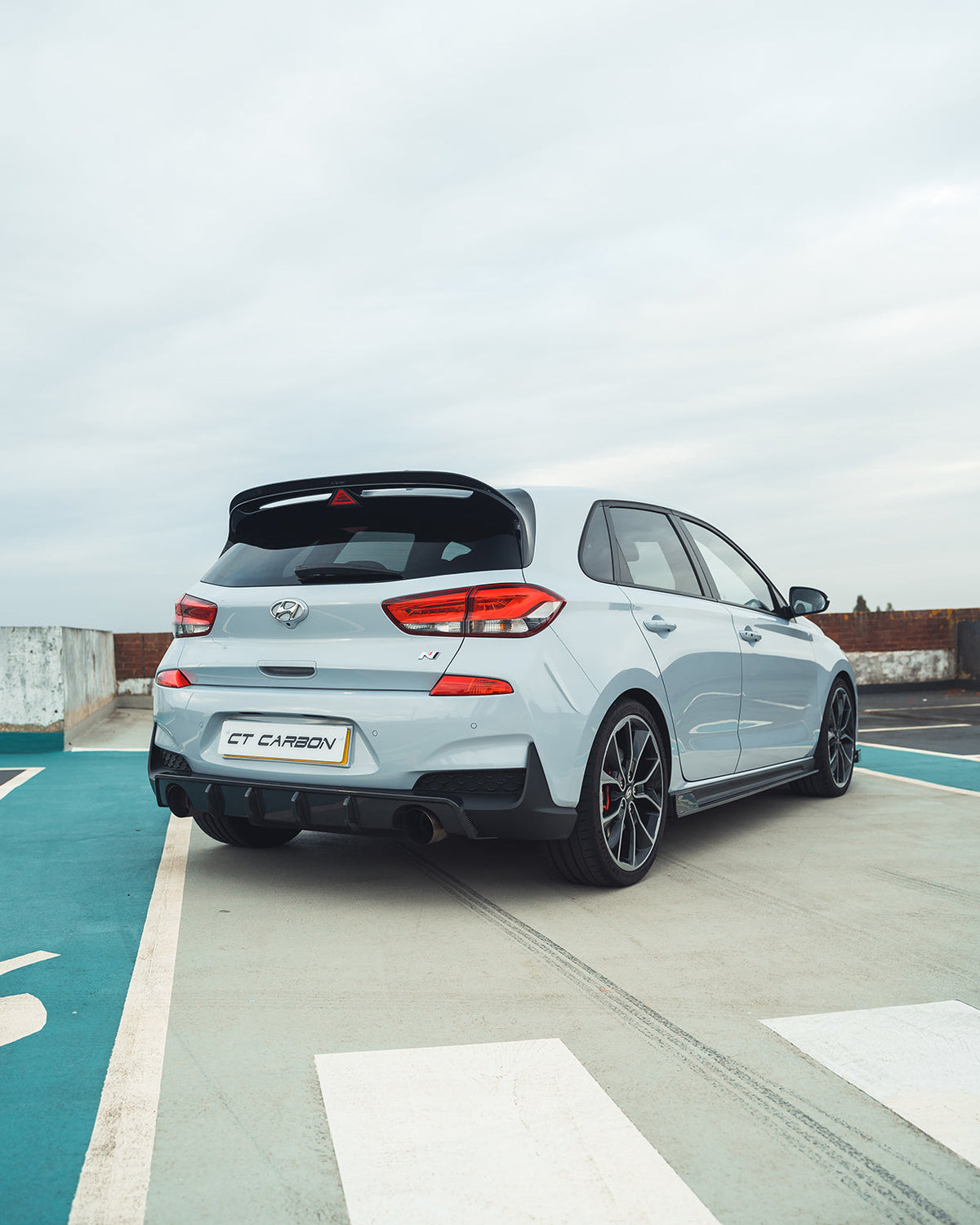 Hyundai i30N carbon fibre diffuser splitter by CT Carbon, pre-facelift model, showcasing sleek carbon fiber finish and aerodynamic design.
