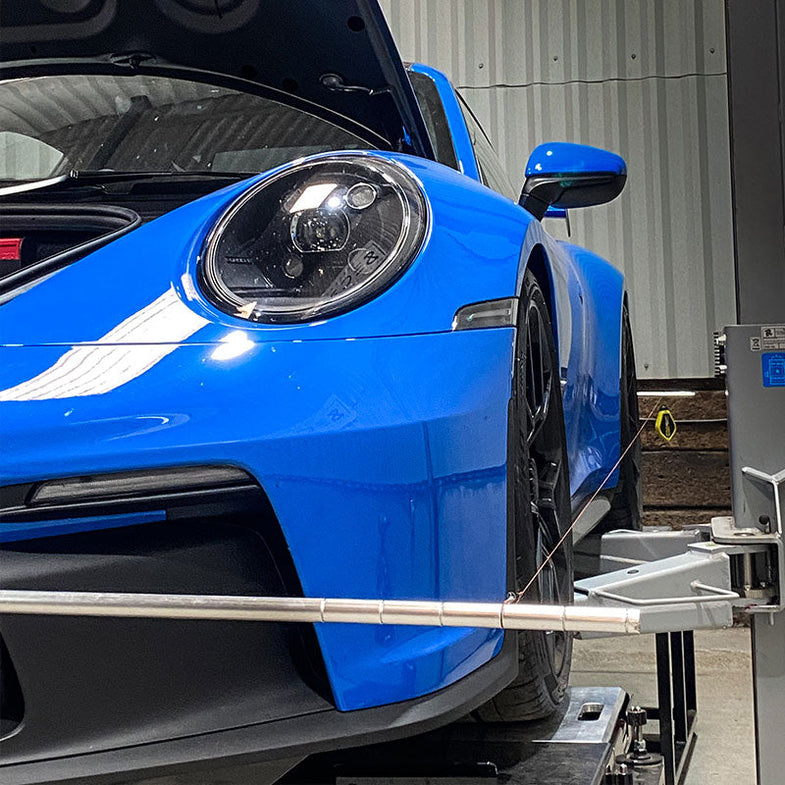 Suspension Secrets rear camber shim kit for Porsche 911 GT3 (992), showing metal shims and linkage components for suspension adjustment.