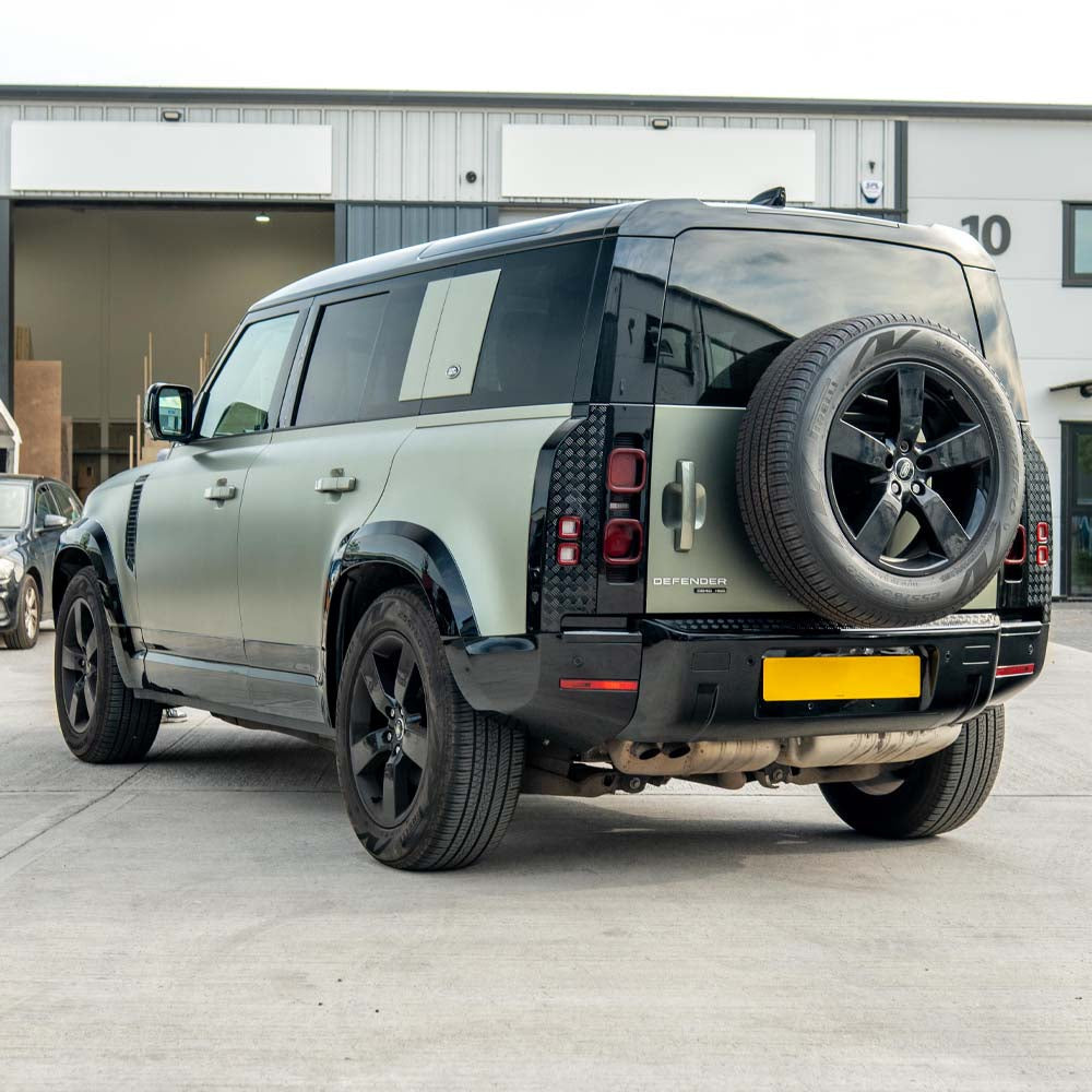 CT Carbon gloss black anti-scratch trim set for Land Rover Defender L663 110, shown installed on vehicle edges and accents.