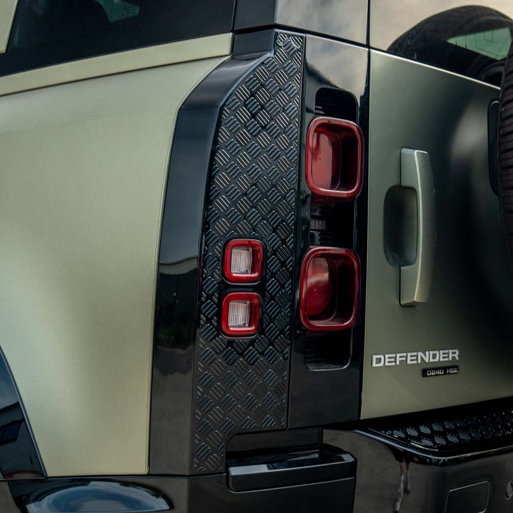 Land Rover Defender L663 110 gloss black anti-scratch trim set installed on vehicle, showcasing sleek, protective exterior accessories by CT Carbon.