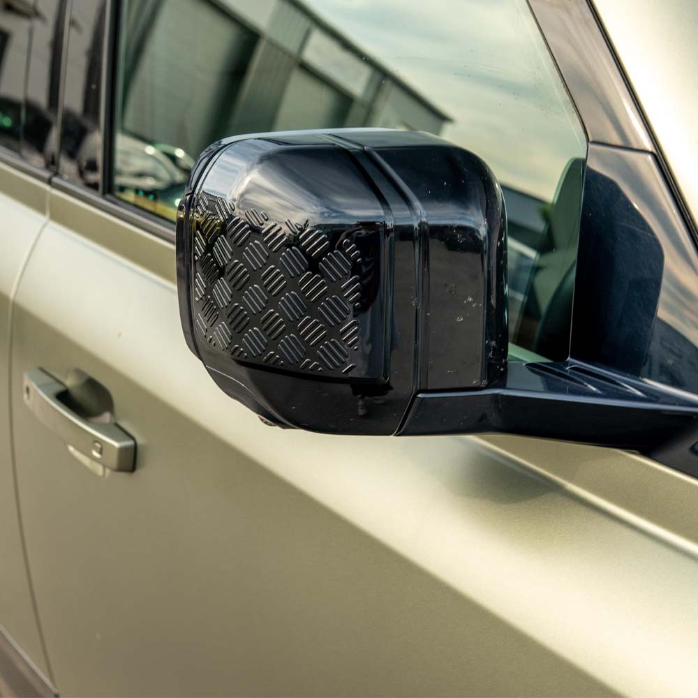 Land Rover Defender L663 110 gloss black anti-scratch trim set by CT Carbon, shown on vehicle parts with a sleek, high-gloss finish.