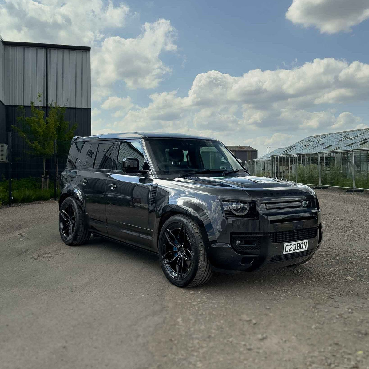Gloss black wide arch fenders for Land Rover Defender L663 110 by CT Carbon, showcasing sleek, durable accessory details.
