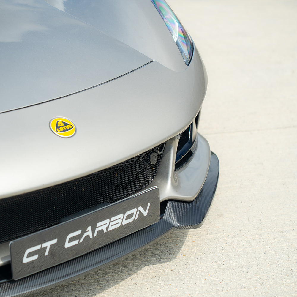 Carbon fiber Lotus Emira front splitter by CT Design, showcasing sleek aerodynamic design and high-quality material details.