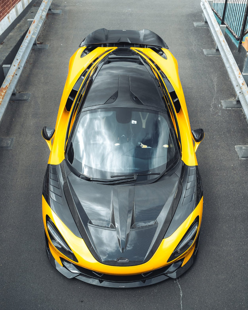 Close-up of CT Carbon McLaren 720S carbon fiber splitter showing detailed weave and aerodynamic design.
