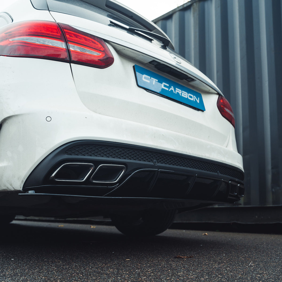 Mercedes C-Class W205 saloon/estate diffuser with gloss black finish and black tips by CT Carbon, shown on a sleek car.