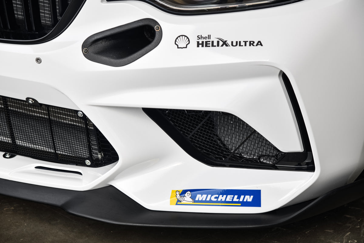 Genuine BMW Motorsport M2 CS Racing front splitter, aerodynamic car part with BMW Motorsport branding and sleek black finish.