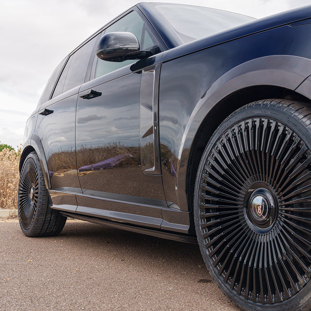 Range Rover L460 2022+ carbon fibre side skirts by CT Carbon installed on vehicle, showcasing sleek design and high-quality finish.