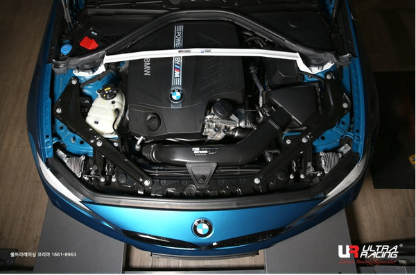 Ultra Racing BMW 2 Series front strut brace installed on engine bay with visible mounting points and structural support.