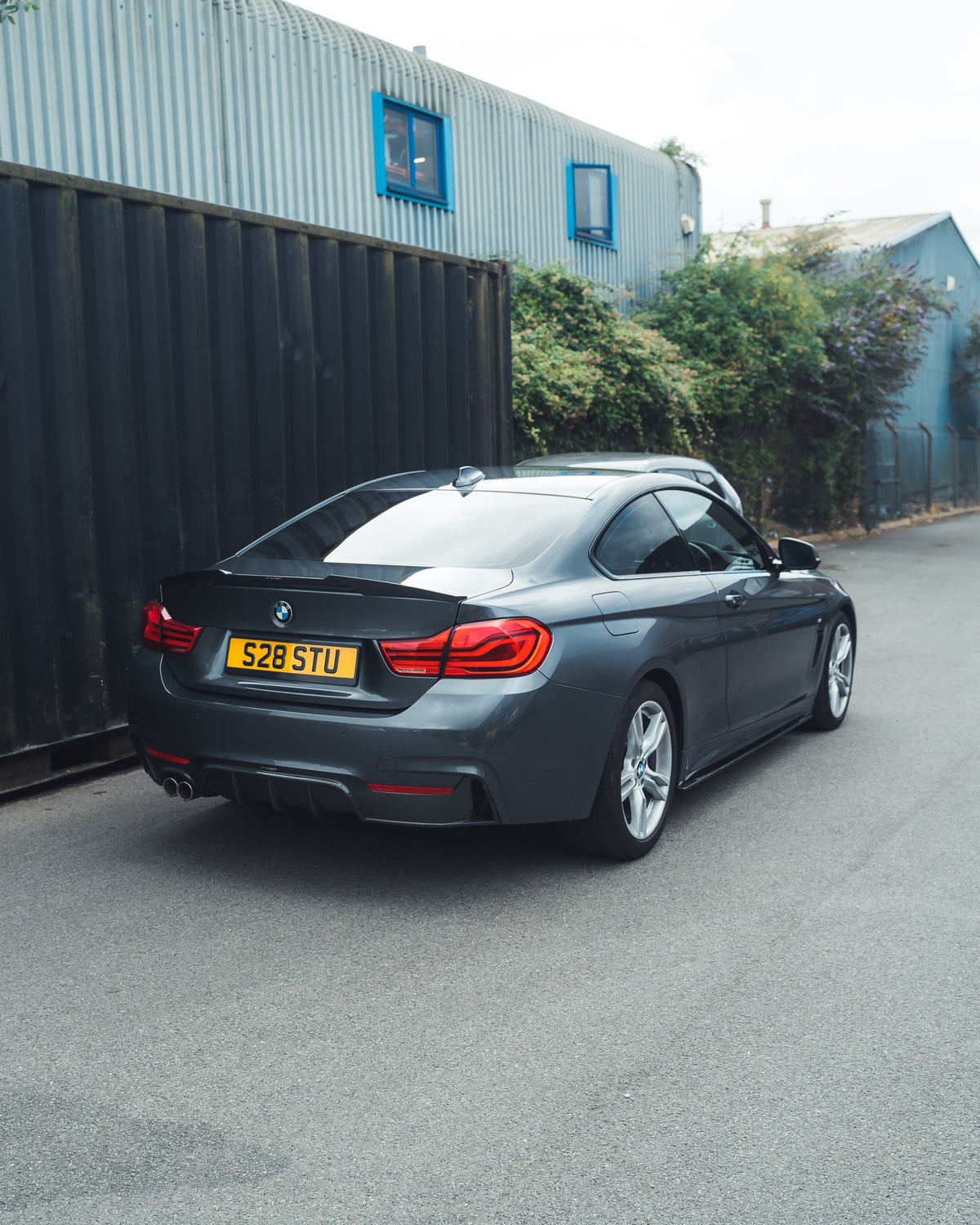 BMW F32 4 Series Carbon Fibre Spoiler by CT Carbon, V1 style, installed on the rear of the sporty coupe, showcasing sleek aerodynamic design.