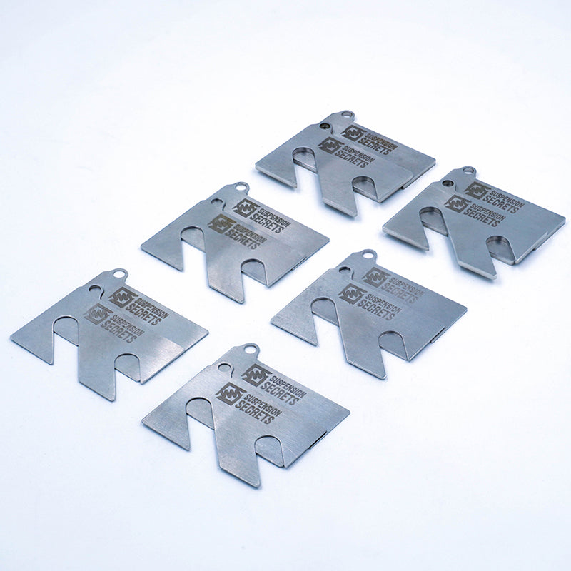 Suspension Secrets front and rear camber shim kit for Porsche 981 and 718 Cayman GT4, showing metal linkage shims for suspension adjustment.