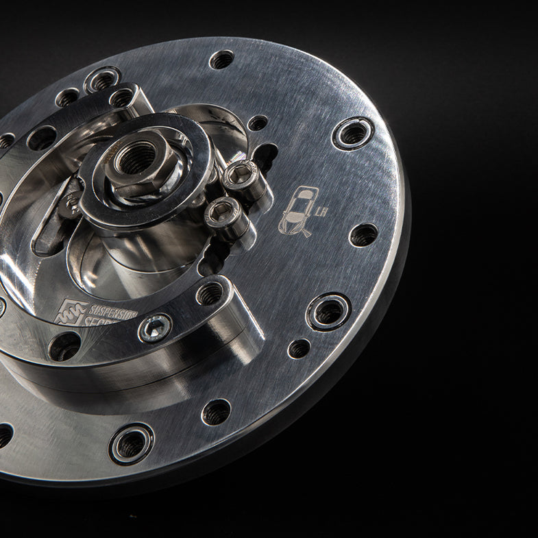 Suspension Secrets adjustable camber and caster plates for BMW F87 M2 Competition, featuring metal linkage components for suspension tuning.